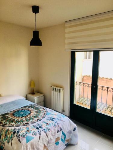 ein Schlafzimmer mit einem Bett und einem großen Fenster in der Unterkunft Vergarillas 1 in Avila