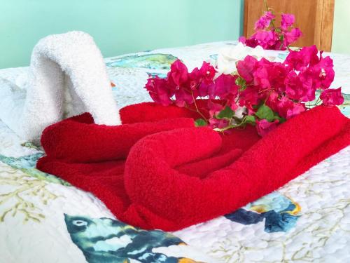 a red towel with a heart and flowers on a bed at Ocean View Villas in Jost Van Dyke