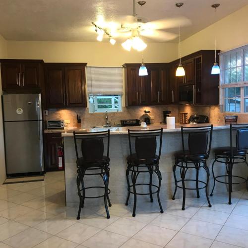 a kitchen with a island with bar stools at Ocean View Villas in Jost Van Dyke
