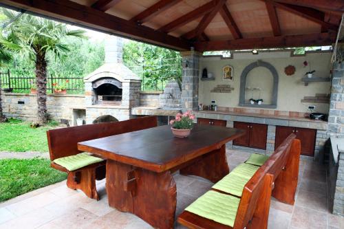 patio con mesa de madera, bancos y horno al aire libre en Harmony INN Apartments Portoroz en Portorož