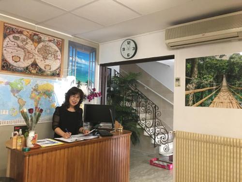 Hotel Paris Star في فيلوجويف: امرأة تجلس في مكتب مع جهاز كمبيوتر
