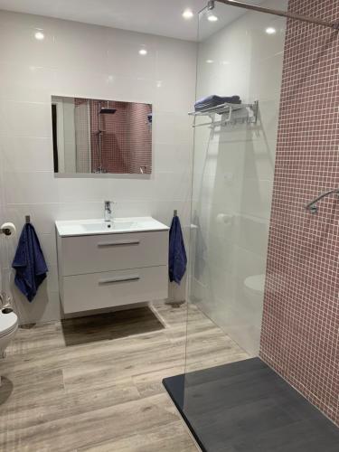ein Badezimmer mit einem weißen Waschbecken und einer Dusche in der Unterkunft Pink Beach Benidorm in Benidorm