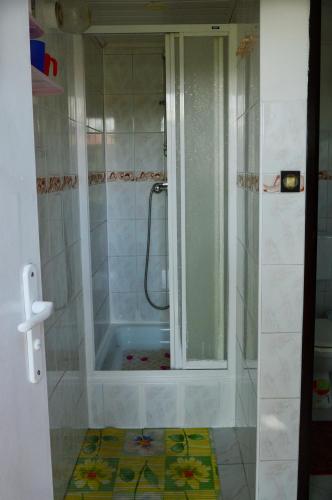 a bathroom with a shower with a tub in it at Domki letniskowe U GOSI in Trzęsacz