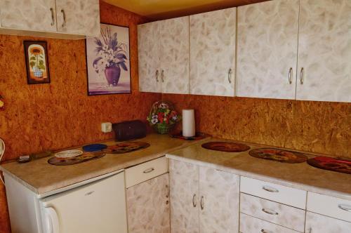 a kitchen with white cabinets and a counter top at Domki letniskowe U GOSI in Trzęsacz