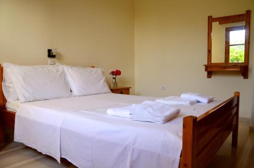 een slaapkamer met een wit bed en handdoeken bij Kostas' Garden in Roda