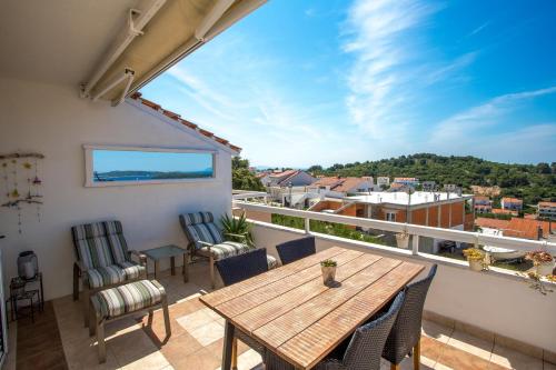 a balcony with a wooden table and chairs at Peaceful apartment with beautiful view in Hvar