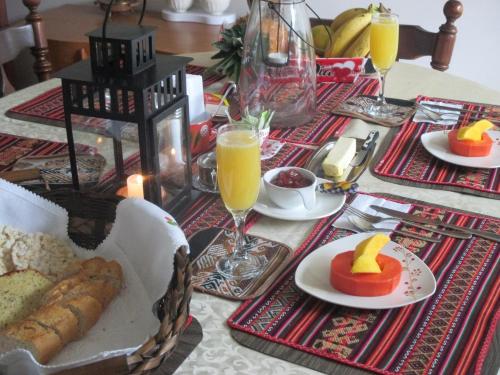 a table with plates of food and glasses of orange juice at Apartaestudio tipo cabaña in Bogotá