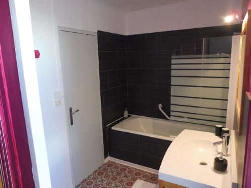 een badkamer met een bad, een toilet en een wastafel bij Ty Lireu in Concarneau