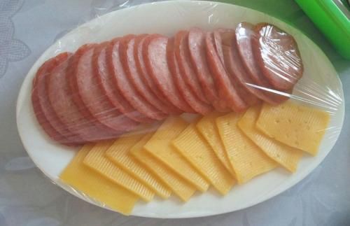 a plate of food with sausage and cheese on it at Hotel "GRAND WAY" in Tashkent