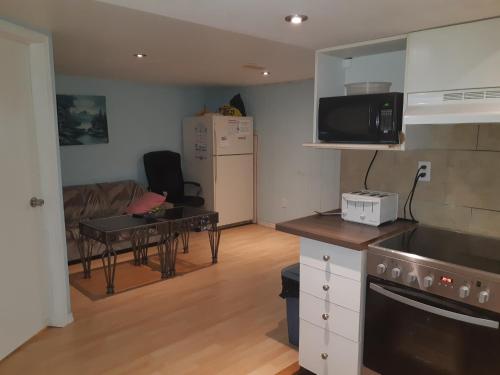 uma cozinha e sala de estar com um sofá e uma mesa em McMaster Accommodations em Hamilton