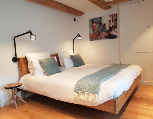 a bedroom with a large bed with two lamps on it at 23 SouS in Amsterdam