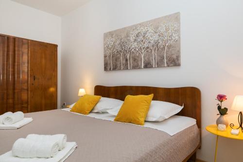1 Schlafzimmer mit 2 Betten und gelben Kissen in der Unterkunft Villa Boško in Kaštela
