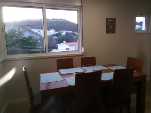 a dining room with a table and a large window at Fish house Sesimbra in Sesimbra