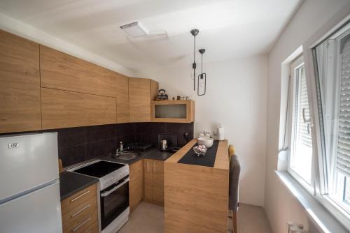 een keuken met houten kasten en een witte koelkast bij La Vecchia Signora APARTMENT in Skopje