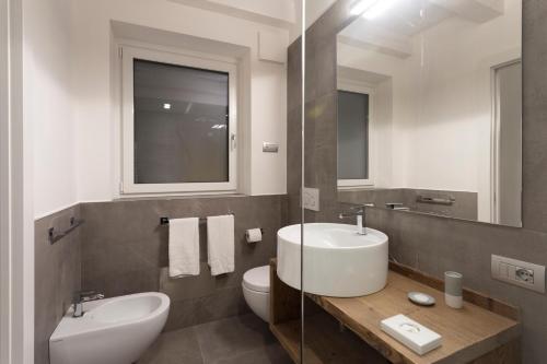 a bathroom with a sink and a toilet and a mirror at Sunset Residence in Brenzone sul Garda