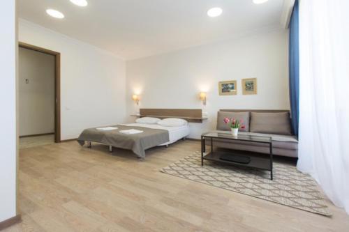 ein Schlafzimmer mit einem Bett, einer Couch und einem Tisch in der Unterkunft Marjanishvili Studios in Tbilisi City