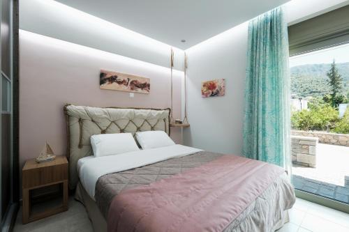 a bedroom with a bed and a large window at Villas Ve in Tyros