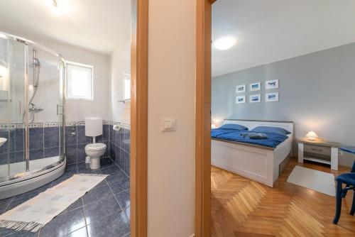 a bedroom with a bed and a bathroom with a shower at Blue Apartment in Vrsar