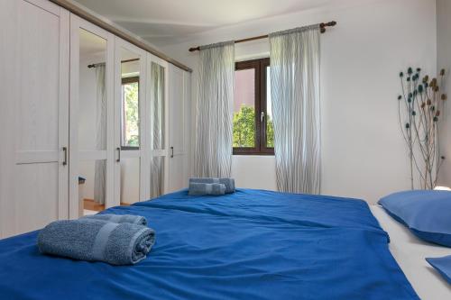 a bedroom with a blue bed with towels on it at Blue Apartment in Vrsar