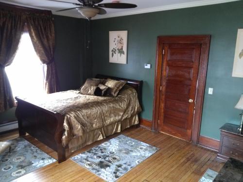 a bedroom with a bed and a ceiling fan at Firehouse Inn in Barre
