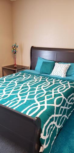 a bedroom with a bed with a green and white comforter at Cozy Condo in Houston