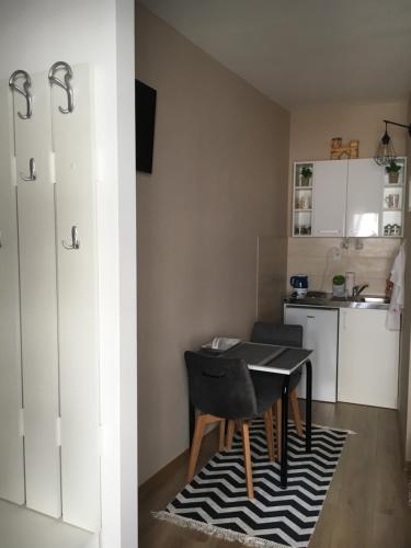 una piccola cucina con tavolo e sedie in una stanza di Apartment Smile a Mostar