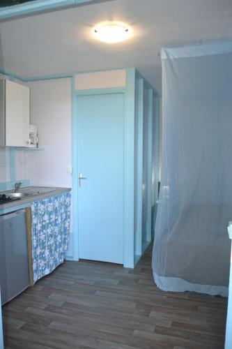 a kitchen with a door with a curtain over it at an eol caraibes in Trois-Rivières