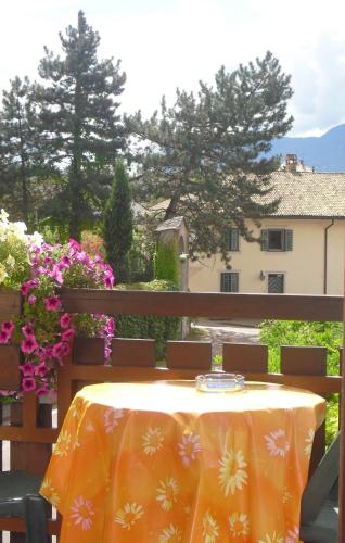 a table with a yellow table cloth on a balcony at Dependance Villnerhof in Egna