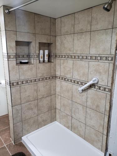 a tiled shower with two bottles of shampoo at Libby's Taos Casita - "The Hideaway" in Taos