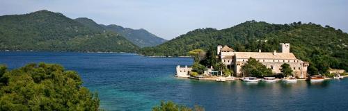 une maison sur une île dans une grande étendue d'eau dans l'établissement Mljet Sunset Apartments, à Pomena