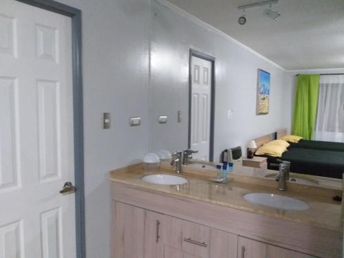 a bathroom with two sinks and a large mirror at Centro Turistico El Quisco in El Quisco