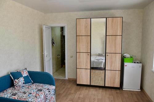 a living room with a blue couch and a large cabinet at Три кошки in Chornomorsk