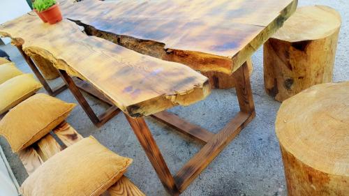 a wooden table with a bench and a table and chairs at Oludeniz Hostel in Fethiye
