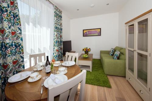 a dining room with a table and a green couch at Best Luxury Apart Hotel in Oxford- Beechwood House in Oxford