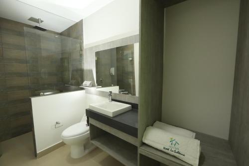 a bathroom with a sink and a toilet and a mirror at Hotel La Sultana Tumaco in Tumaco