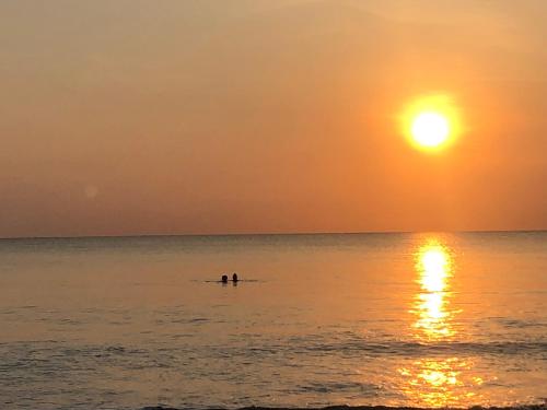 two people kayaking in the ocean at sunset at Moon Isle Beach Bungalow in Nilaveli