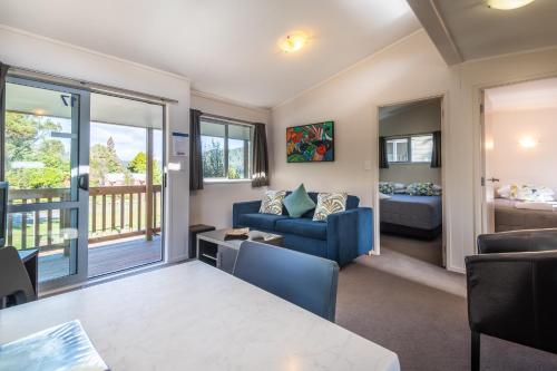 a living room with a couch and a table at Blue Lake TOP 10 Holiday Park in Rotorua