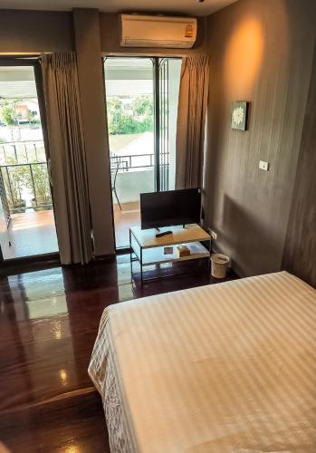a bedroom with a bed and a living room with a balcony at Baan Keang Chon Ayutthaya บ้านเคียงชล อยุธยา in Phra Nakhon Si Ayutthaya