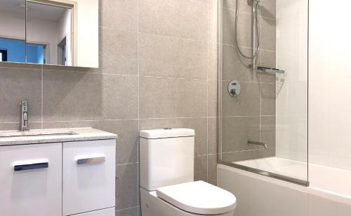 a bathroom with a toilet and a shower and a sink at Nice and Clean Apartment with Free Wifi and Netflix in Bankstown