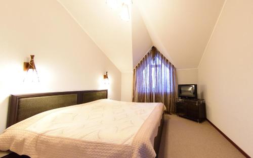 a bedroom with a large bed and a window at Zlata Inn in Tamchy