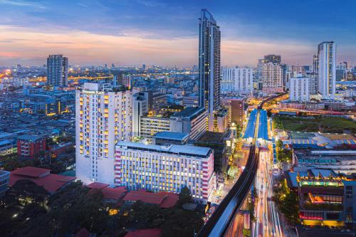 a city skyline at night with traffic on a freeway at Evergreen Place Siam by UHG in Bangkok