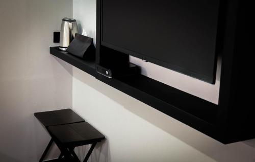 a tv on a wall with a black shelf at Hotel Lumia Myeongdong in Seoul
