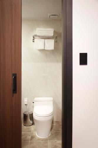 a white toilet in a bathroom with towels at Hotel Lumia Myeongdong in Seoul