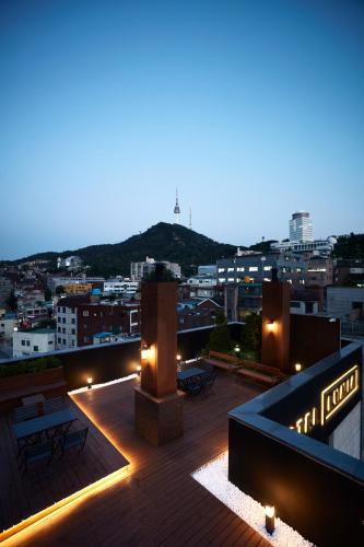 a rooftop with a view of a city at night at Hotel Lumia Myeongdong in Seoul