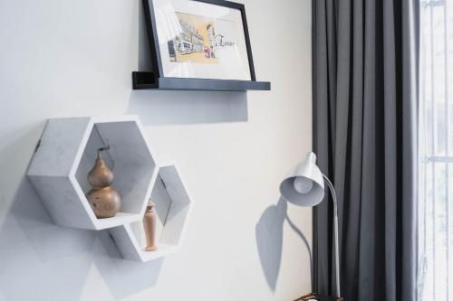 a shelf on a wall with a picture and a lamp at Lai Jia I 鄰近花園夜市 in Tainan