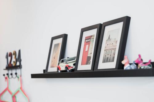 a shelf with three pictures and toy cars on it at Lai Jia I 鄰近花園夜市 in Tainan
