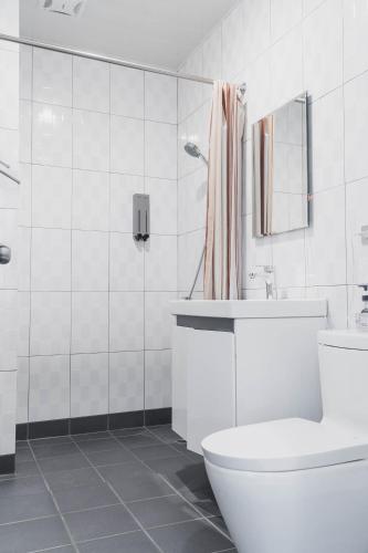 a white bathroom with a toilet and a sink at Lai Jia I 鄰近花園夜市 in Tainan
