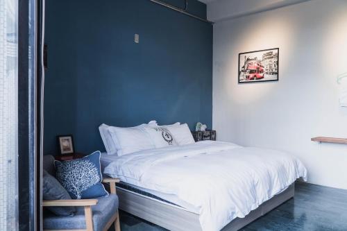 a bedroom with a bed with a blue wall at Lai Jia I 鄰近花園夜市 in Tainan