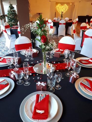 a black table with red and white plates and glasses at Anchor Inn and Suites in Campbell River