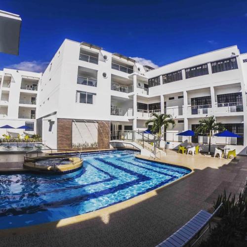 a building with a large swimming pool in front of a building at Hotel Anapoima in Anapoima